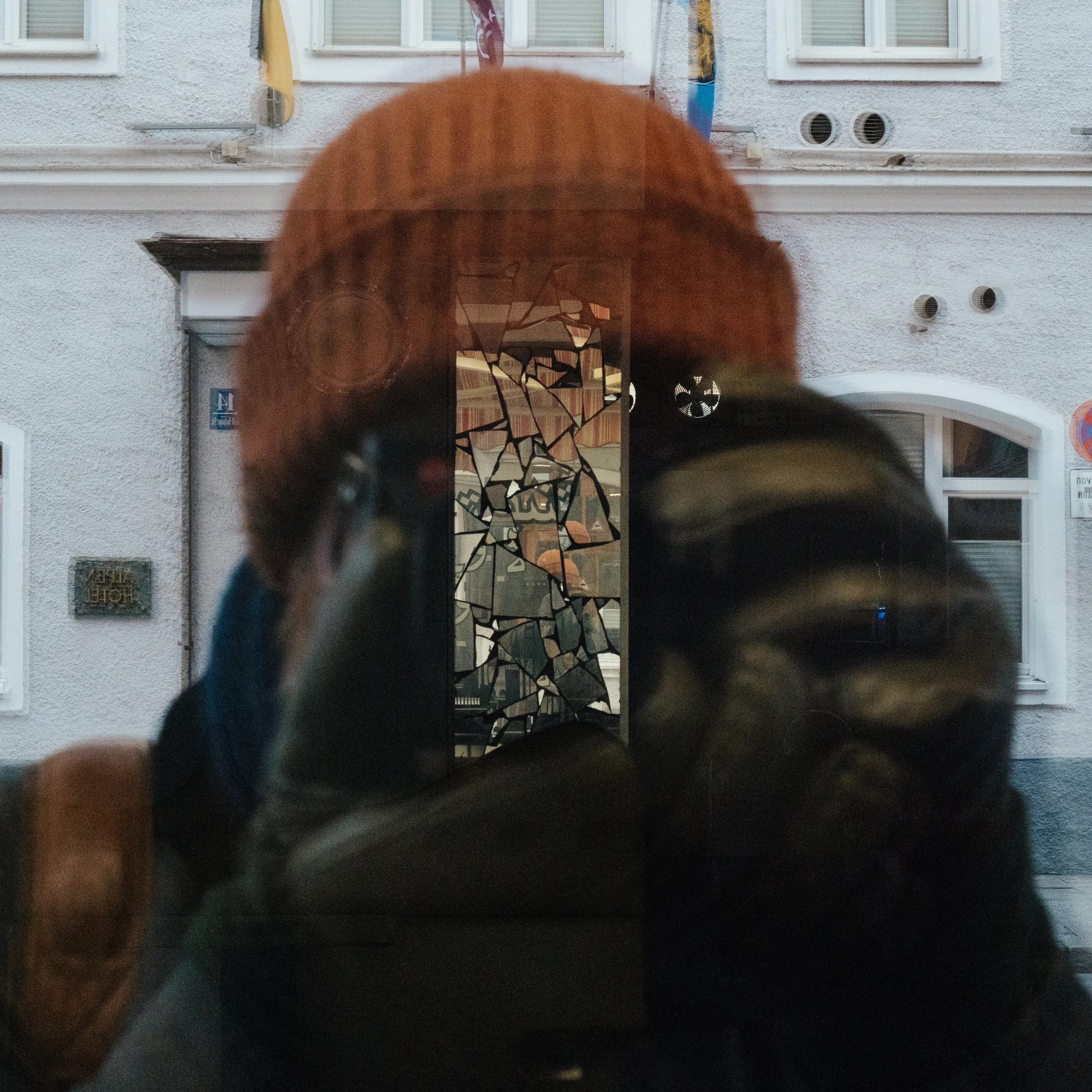 A self portrait taken through glass and a broken mirror