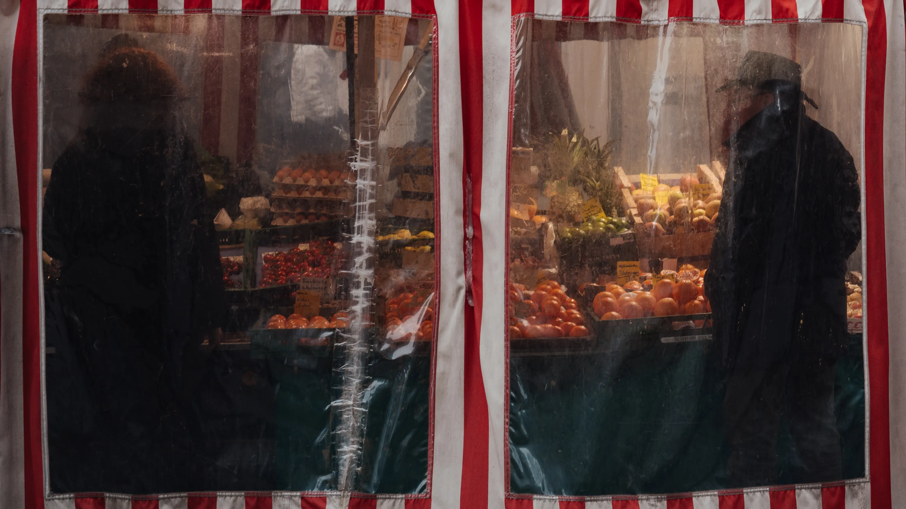 Two people buy food in a tent